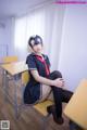 A woman in a school uniform sitting at a desk.