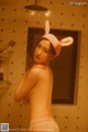 A woman in a bunny hat is taking a shower.