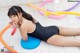 A woman in a black bathing suit laying on the floor.