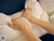 A woman laying in bed with her hands on a pillow.