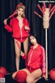 A couple of women in red outfits posing for a picture.