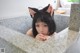 A woman in a bathtub with a cat ears on her head.