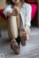 A woman sitting on the floor holding a pair of black stockings.