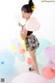 A woman standing in front of a bunch of balloons.