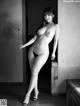 A naked asian woman standing in a room.