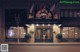 A woman standing in front of a hotel at night.