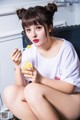 A woman sitting on a chair eating a bowl of food.