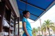 A woman in a blue shirt standing in front of a counter.