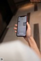 A person holding a smart phone with a keyboard on the screen.