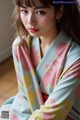 a woman wearing a pink and yellow kimono