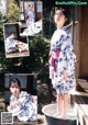 A woman in a blue and white kimono sitting in a tub.