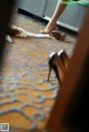 A woman is putting on her wedding shoes on the floor.