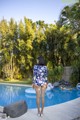 A woman standing in front of a swimming pool.